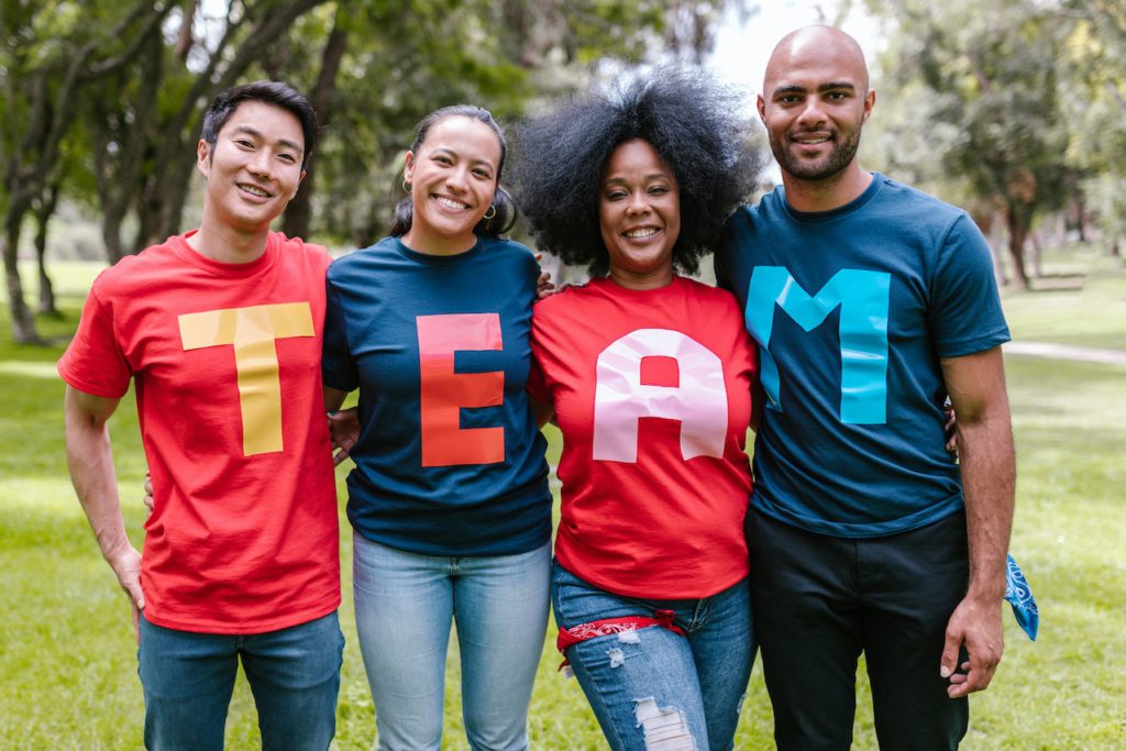 four-people-with-t-shirts-spelling-team