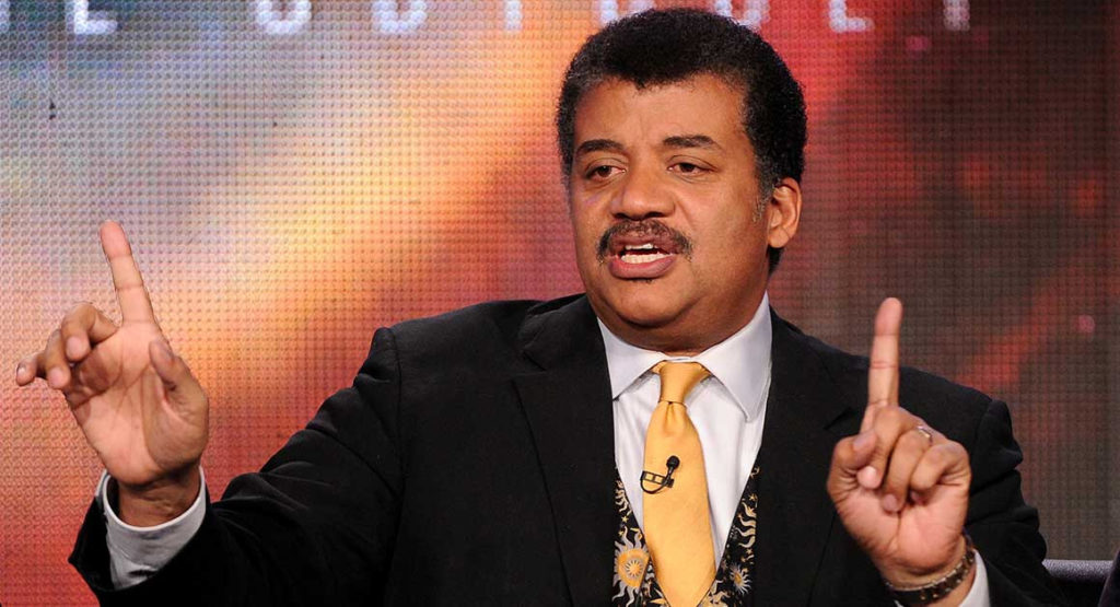 Neil deGrasse Tyson engaging an audience with a cosmic-themed presentation.