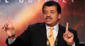Neil deGrasse Tyson engaging an audience with a cosmic-themed presentation.